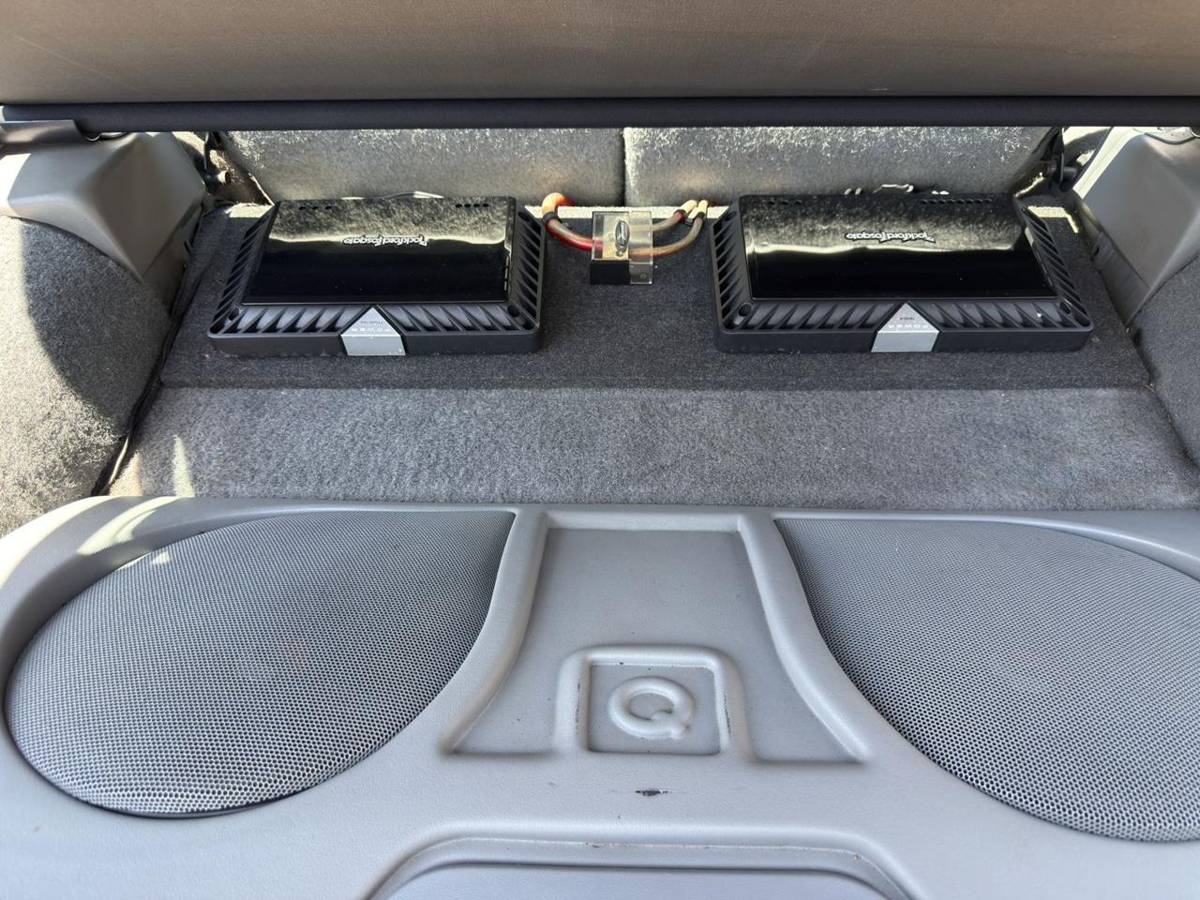 Two Rockford Fosgate amplifiers mounted with capacitor above custom subwoofer enclosure